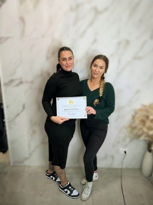The business owner proudly holding a certificate after completing a course on permanent makeup artistry, showcasing their expertise and commitment to professional cosmetic services.
