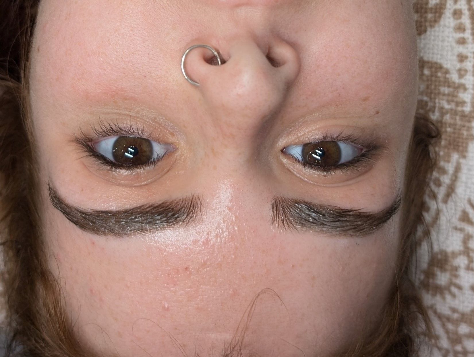Close-up after shot of eyebrows, showcasing the results of the cosmetic tattooing procedure.