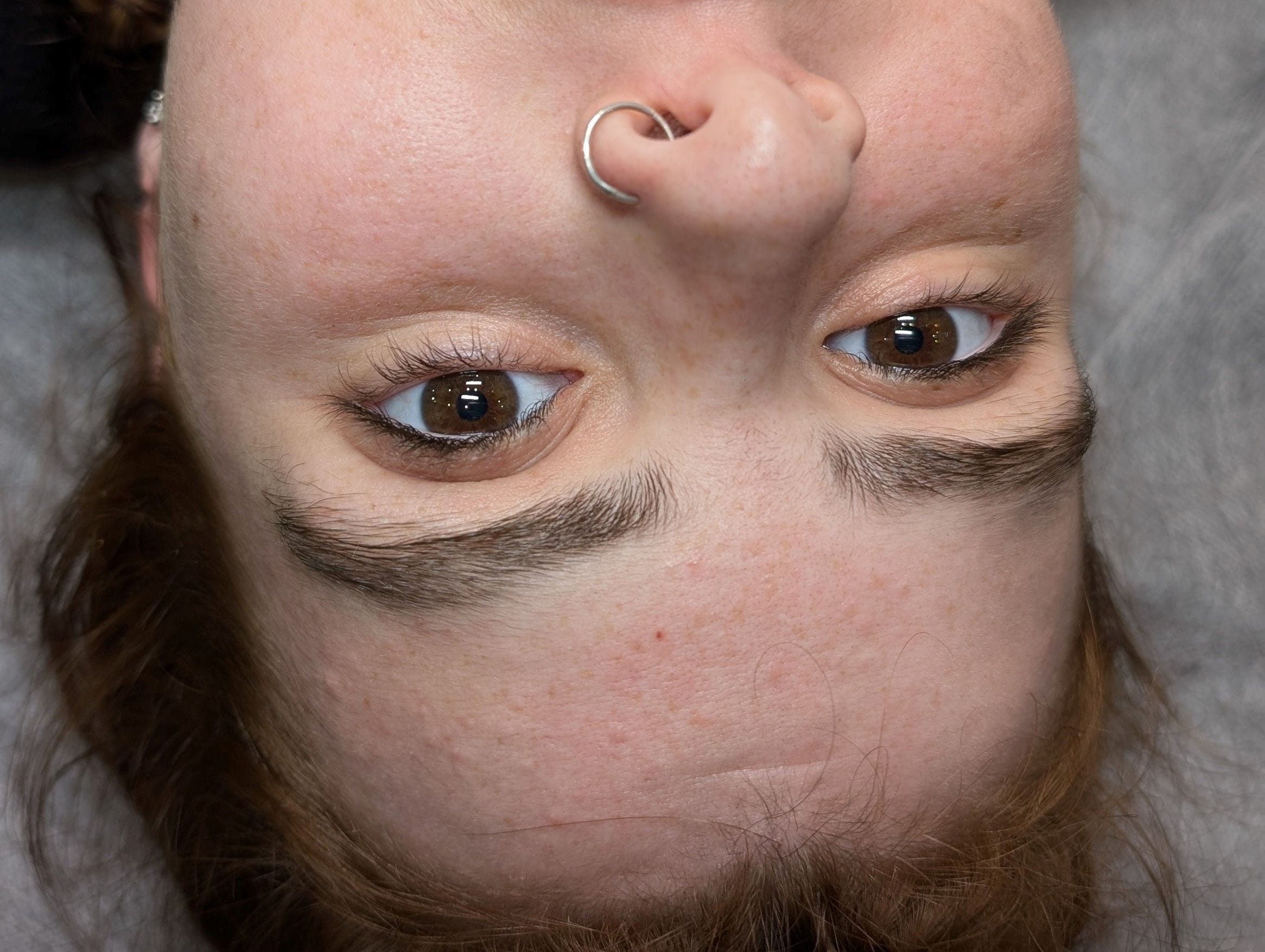 Close-up before shot of eyebrows, showing their natural state before cosmetic tattooing.
