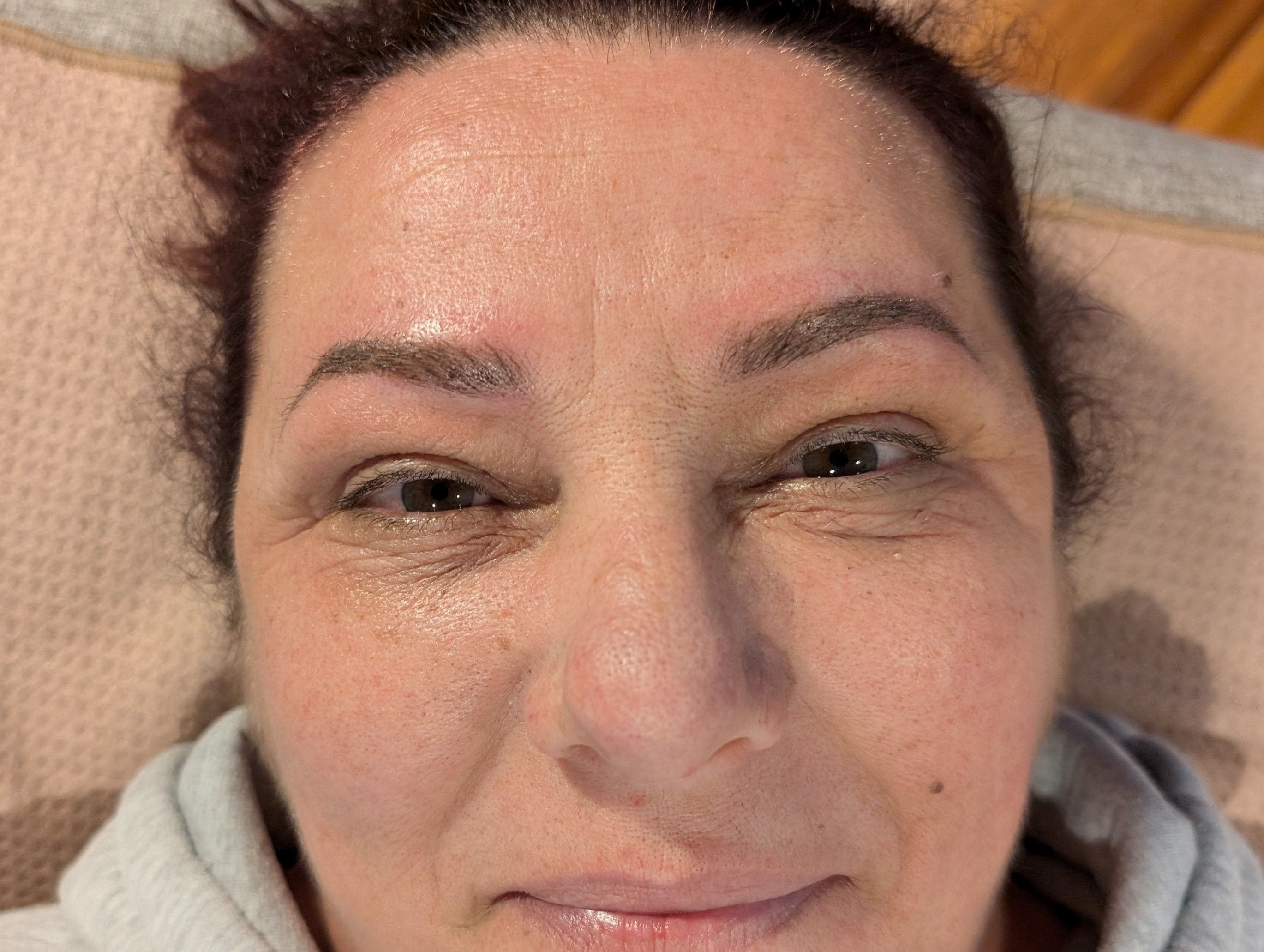 The after image to compare the unkempt natural eyebrows and the polished look achieved with cosmetic tattooing.